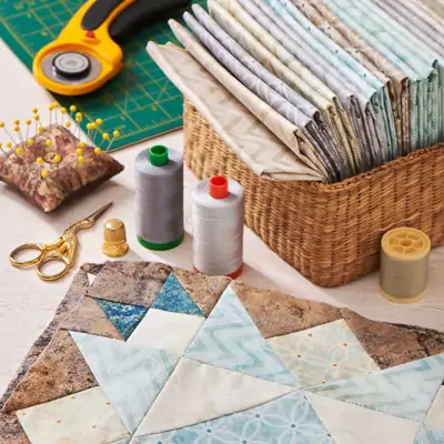 Attrezzatura, tessuti e un blocco patchwork